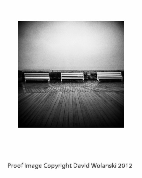 Three benches on the boardwalk at Rehoboth Beach on a rainy day